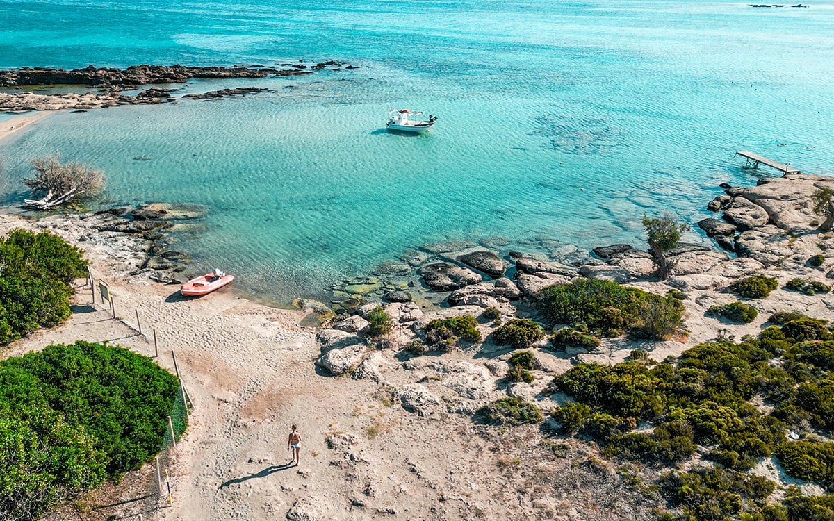 Aerial view of Elafonisi Beach, showcasing its unique pink sand shoreline and vibrant blue waters.