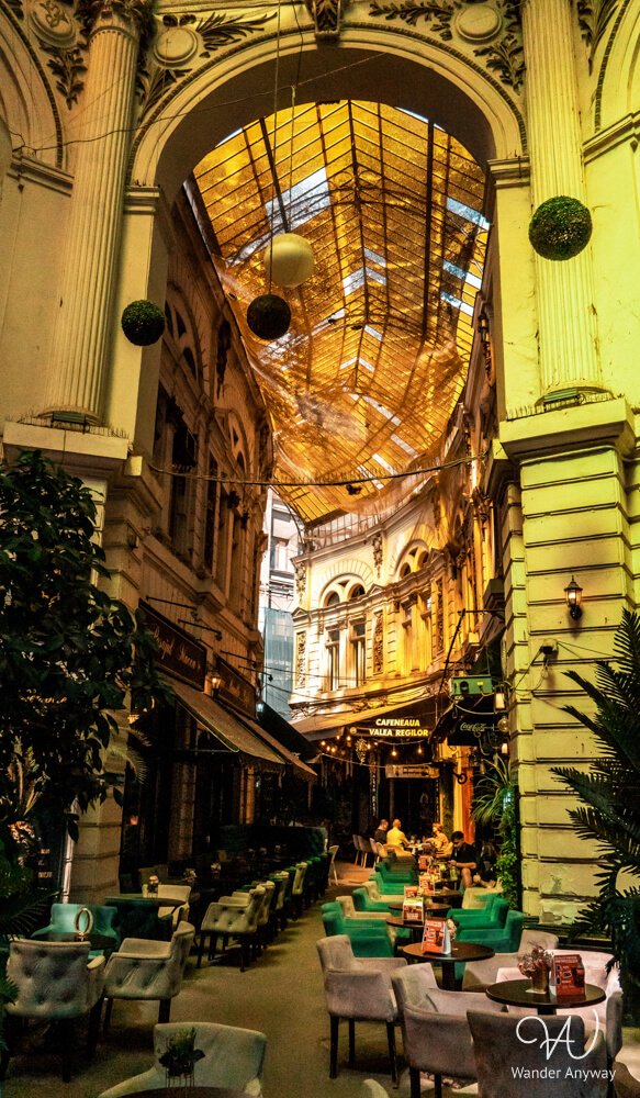 Macca-Vilacrosse Passage in Bucharest with yellow glass roof and glowing evening lights.