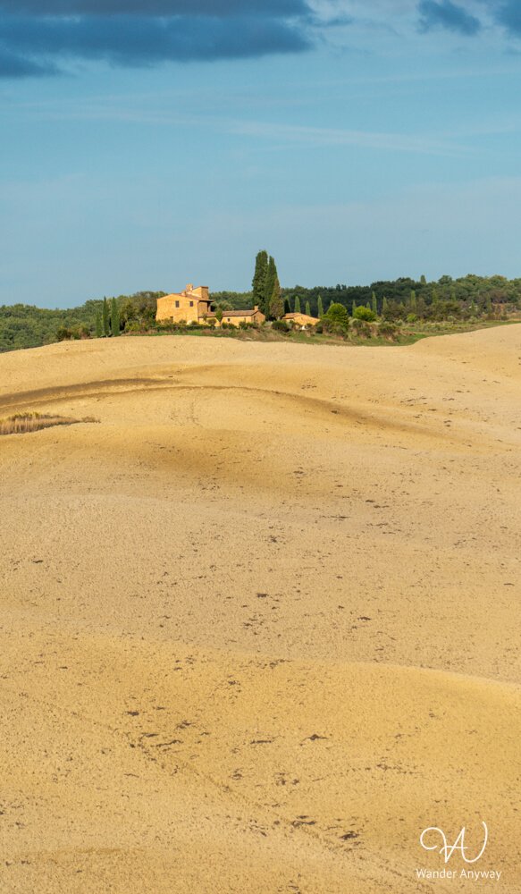 Bright golden hills with traditional Tuscan farmhouse during autumn