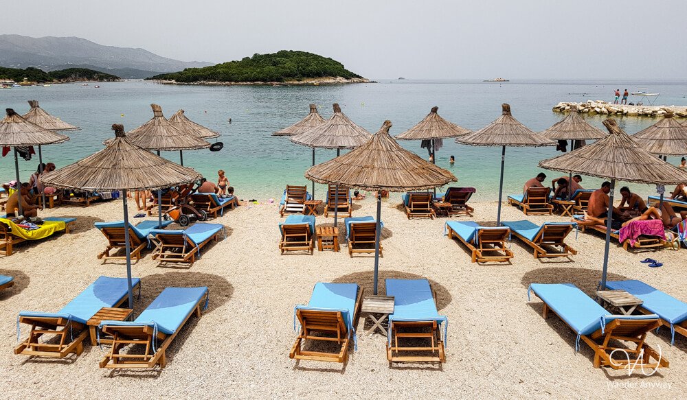 Wooden sunbeds and straw umbrellas on Ksamil Beach, Albania