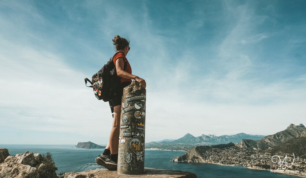 Hiker standing on the Peñón de Ifach rock with sea view
